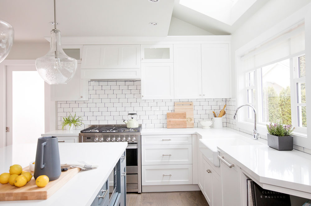 Bright and white modern kitchen design with subway tile backsplash and black grout.