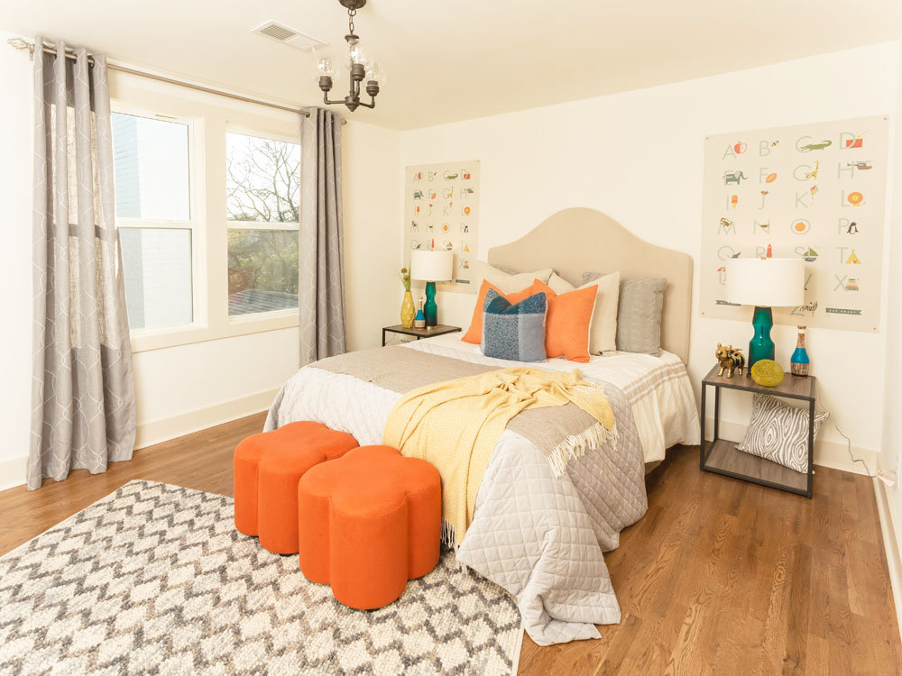 Kids' room with fabric headboard, clover-shaped poufs and large matching art pieces.