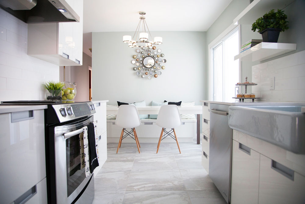 Timeless white kitchen with a large banquette and floating shelves.