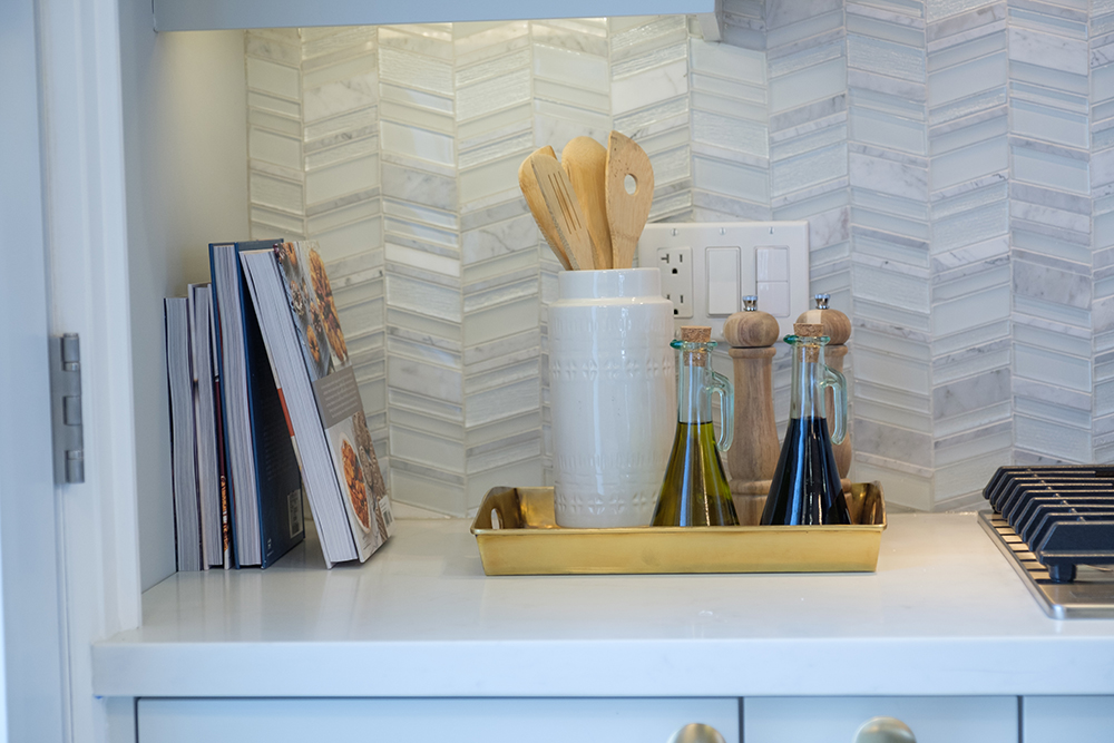 A chic chevron kitchen backsplash used glass and stone tiles to create the desired effect