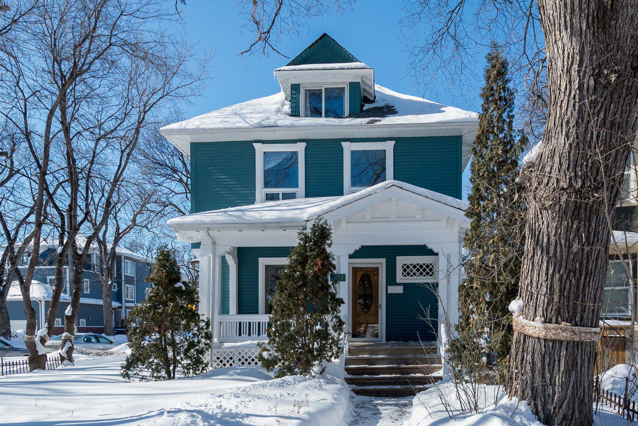 Snow-covered three-storey home painted blue and white