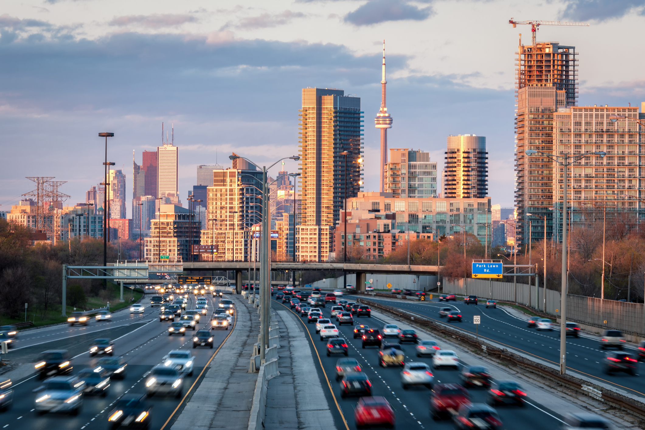 Toronto city skyline at sunset set beyond commuter traffic filling roadway