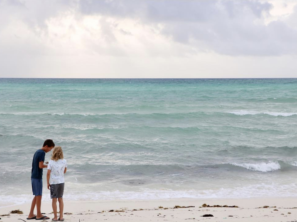 Quintyn and Lincoln Baeumler go beachcombing together on a white sand beach