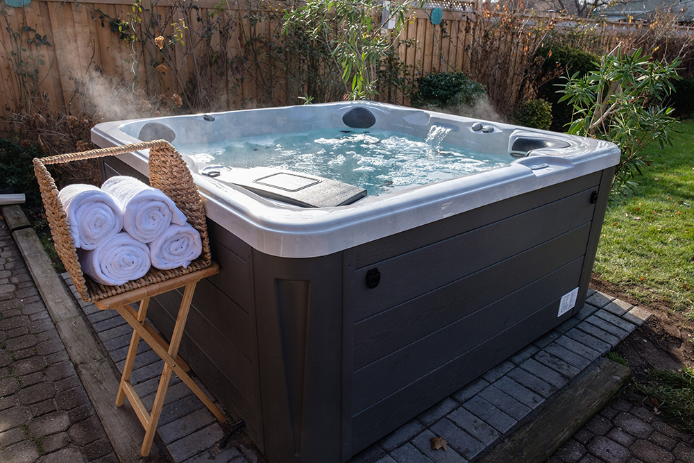 A new bubbling hot tub in a landscaped backyard