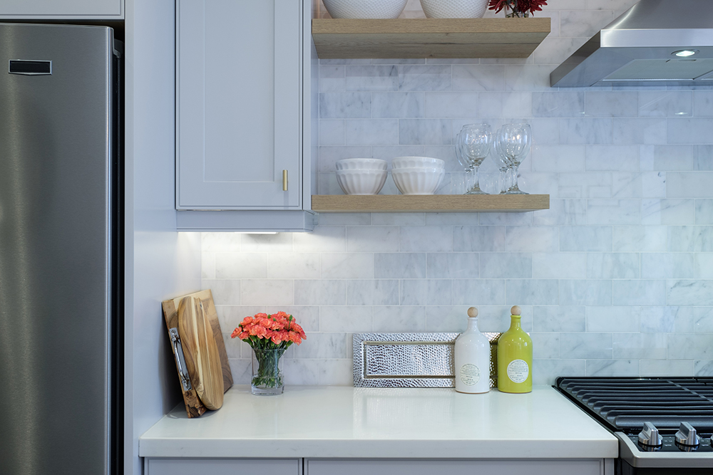 White modern kitchen with quartz countertops and light oak floating shelves
