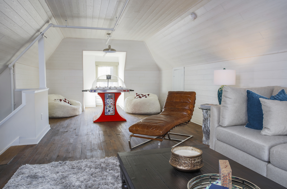 Attic converted into character-filled family room with modern furnishings and games.