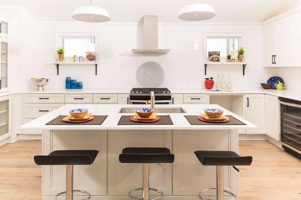 Masters of Flip primary colour renovation white kitchen island with primary-colour place settings and black bar stools