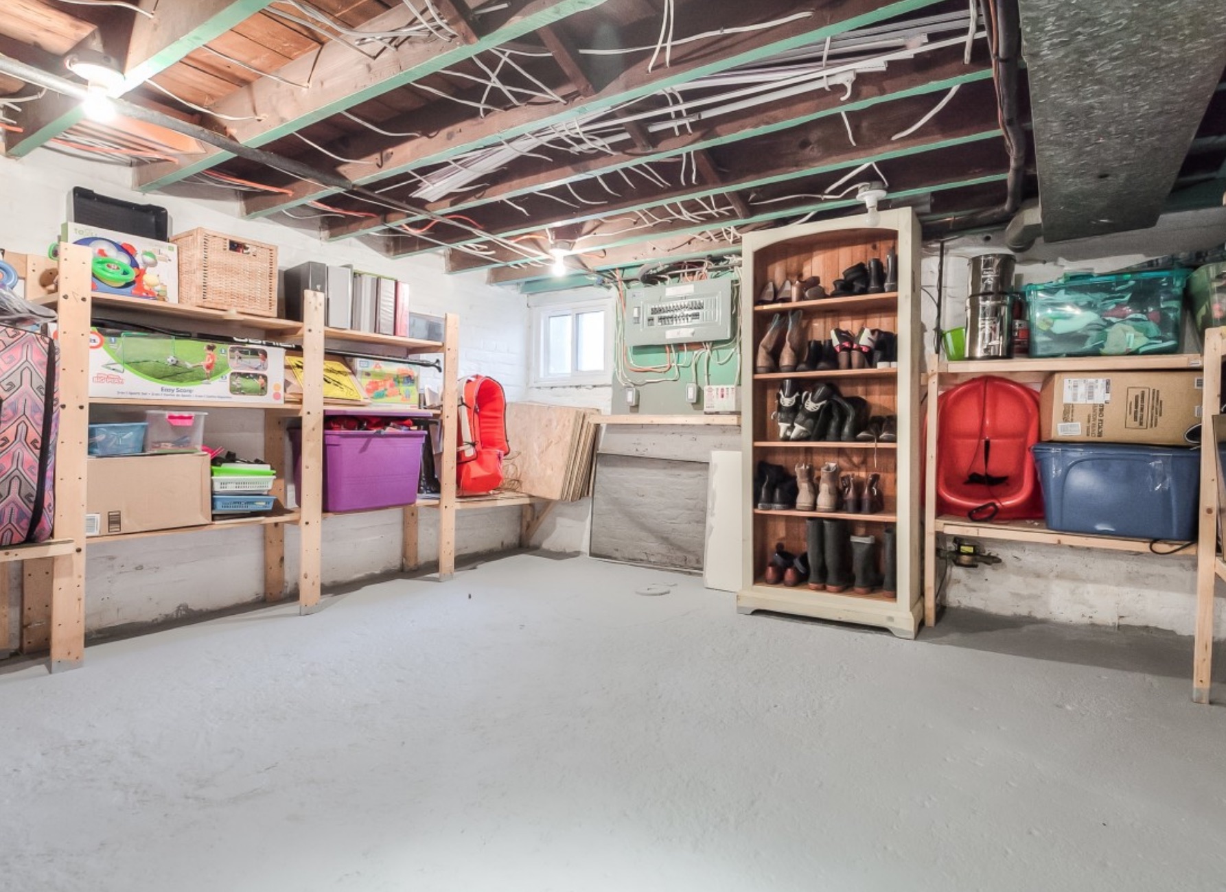 An unfinished basement with plenty of storage space and shelving