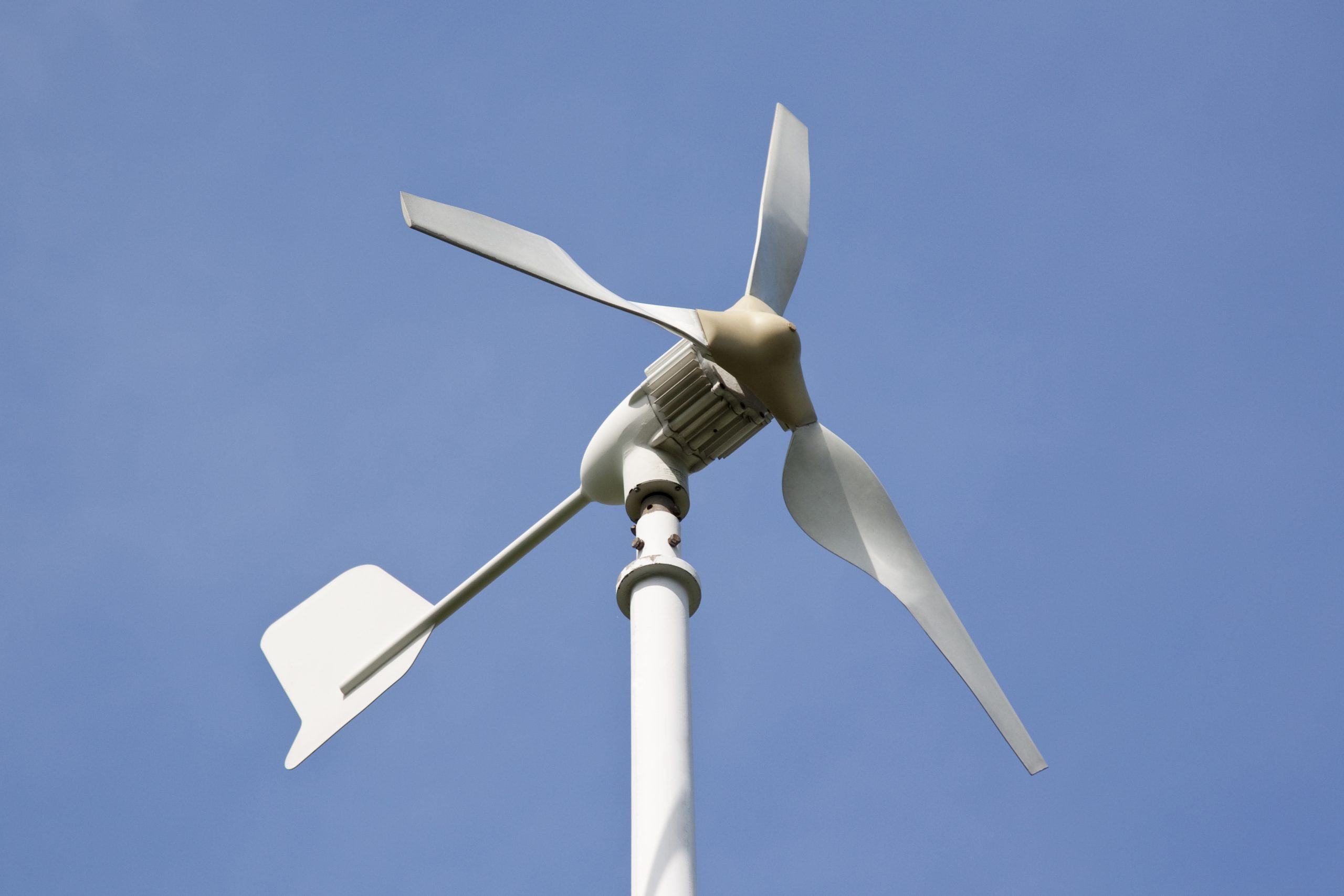 Small wind turbine against blue sky