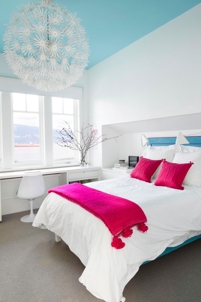 bedroom with blue ceiling and hot pink cushions and throw