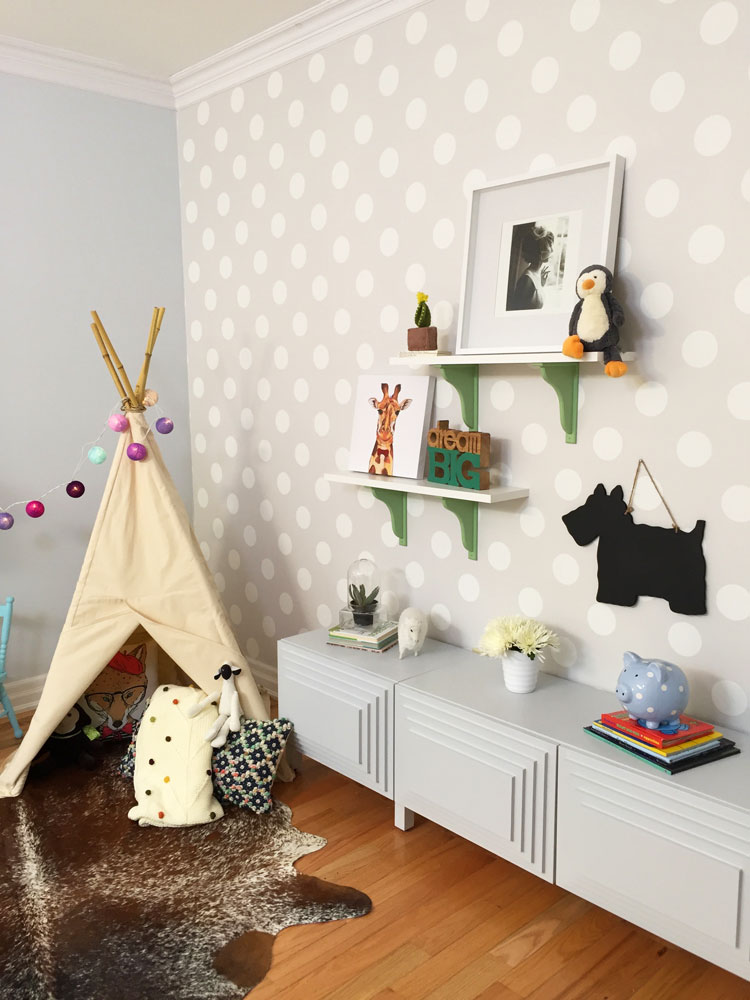 Grey and soft yellow playroom with polka-dot accent wall.