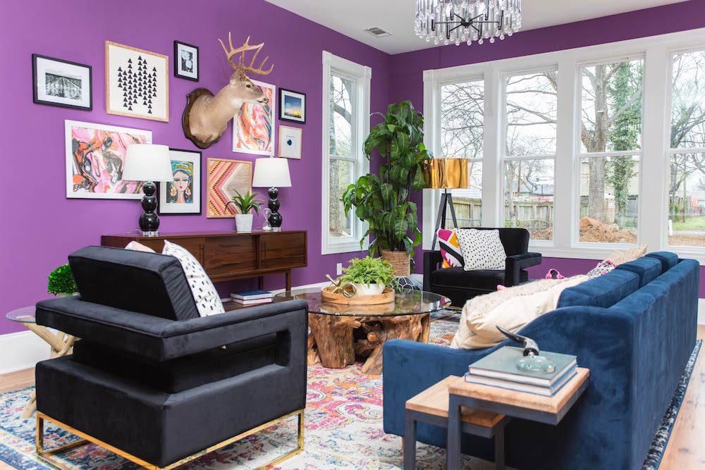 Masters of Flip bohemian Victorian house living room blue velvet couch and purple wall with artwork and deer taxidermy