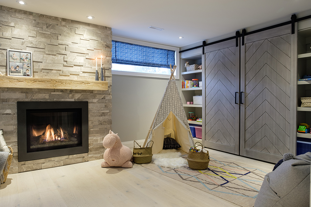 Stylish family room with gas fireplace, pink stuffed horse, a play teepee and grey barn doors