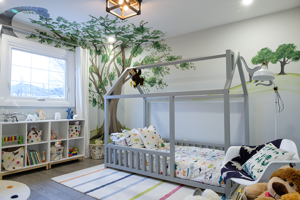 Cool kids room with a grey playhouse bed and dinosaur mural on the wall