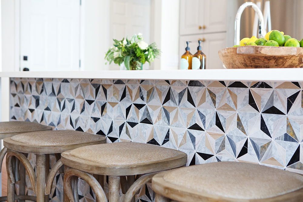 Rattan stools and optical-illusion tiles in a contemporary kitchen