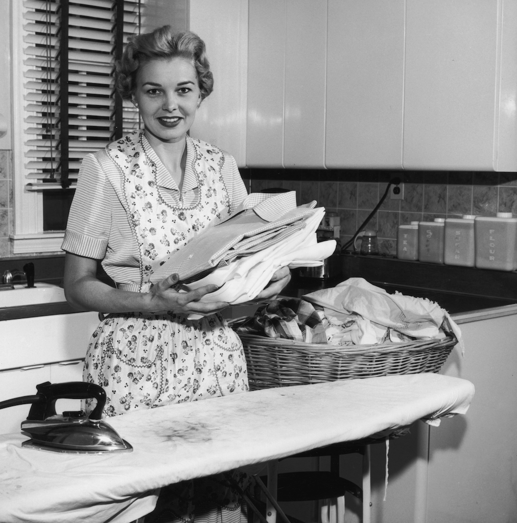 Woman doing laundry in 1930s kitchen