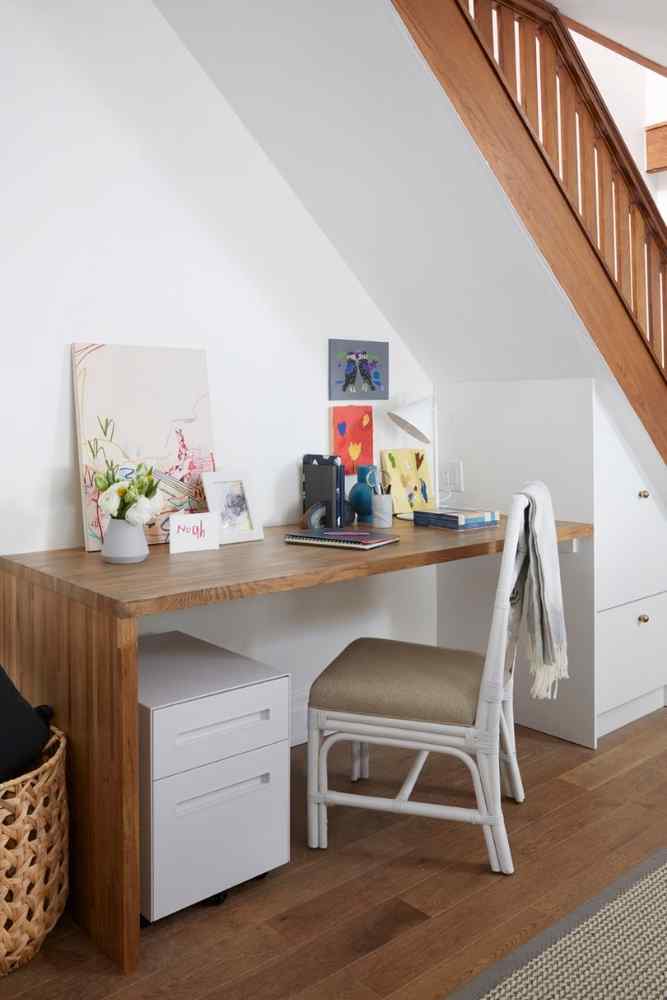 A custom made desk with built-ins under the stairs