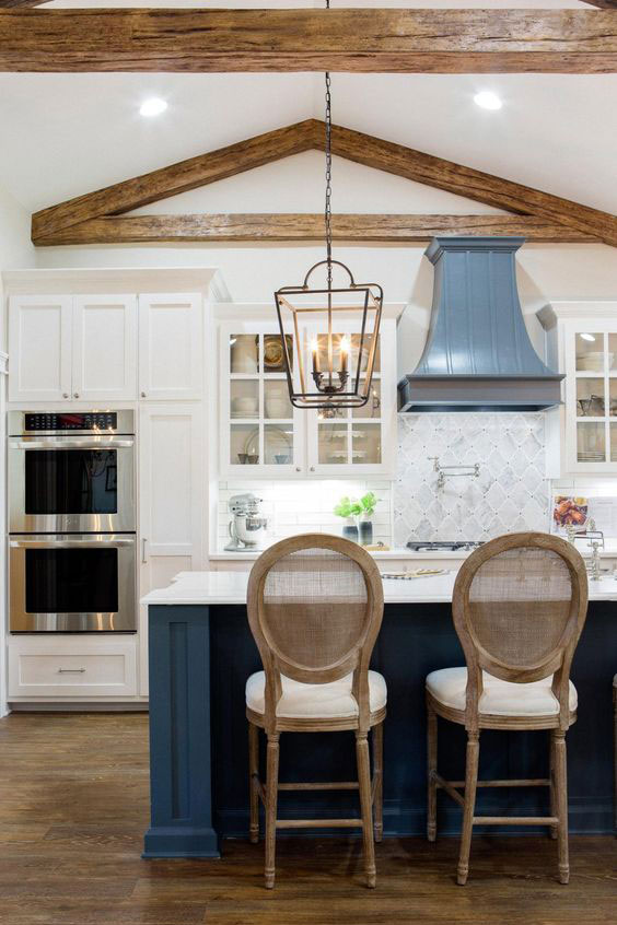 Rustic chic kitchen design by Joanna Gaines with dark blue island and patterned backsplash.