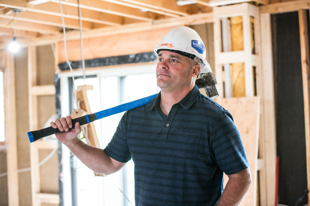 Bryan Baeumler holding sledge hammer during renovation project.