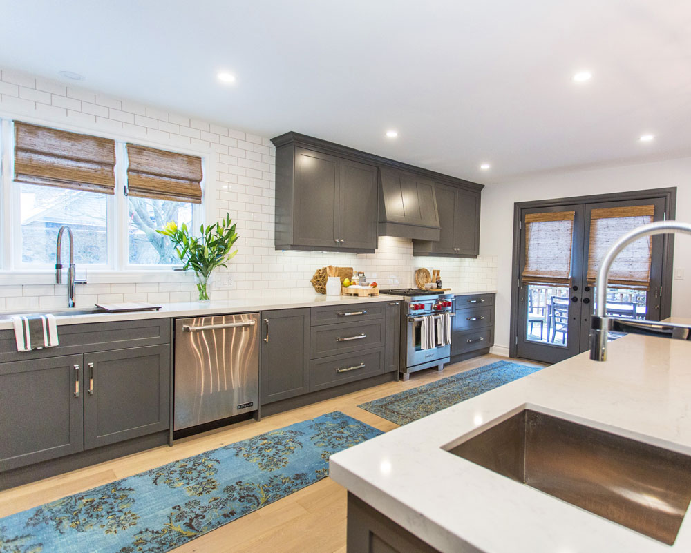 Bright modern kitchen with grey cabinetry and white subway tile backsplash.