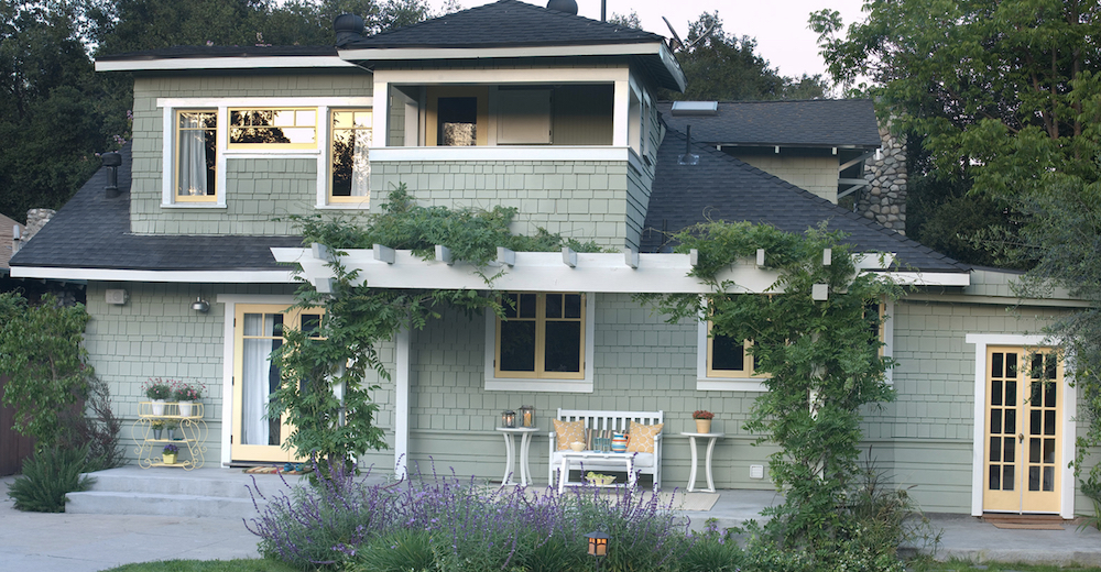 Exterior of a beautiful shingled home painted a silver green in BEHR Environmental PPU11-09 with white and yellow window trim and doors in BEHR Ultra Pure White® PPU18-06 and Marsh Marigold P250-3