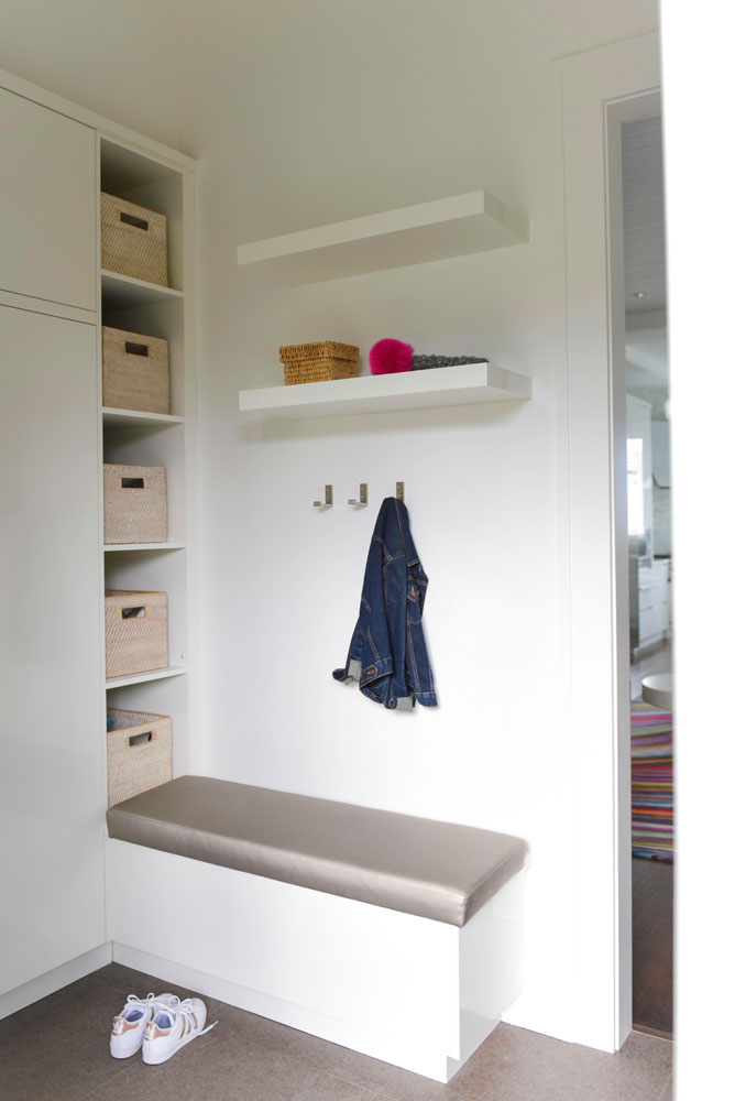 mudroom with grey top bench and and three steel wall hooks