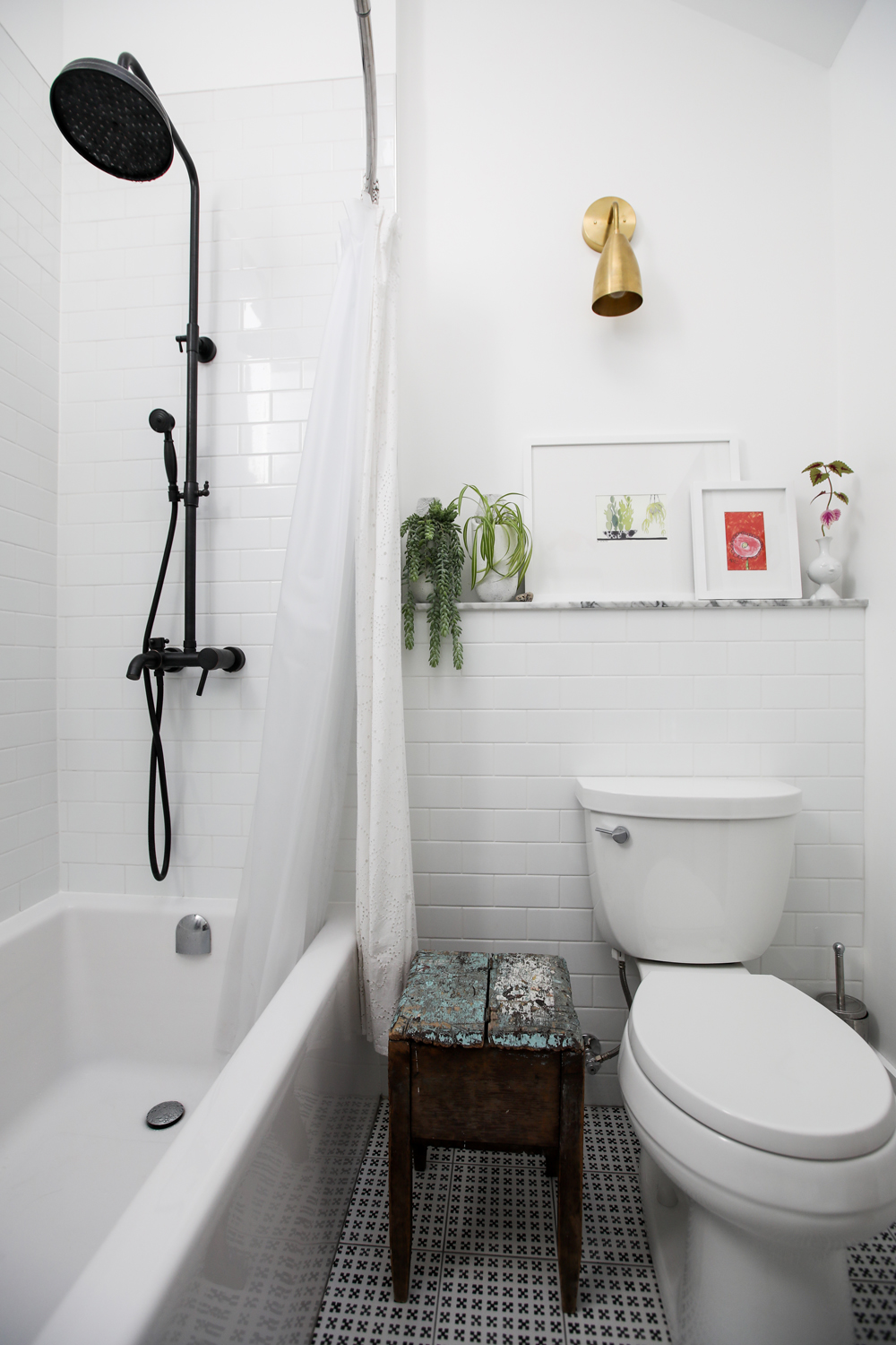 White bathroom with statement gold light and plant shelf