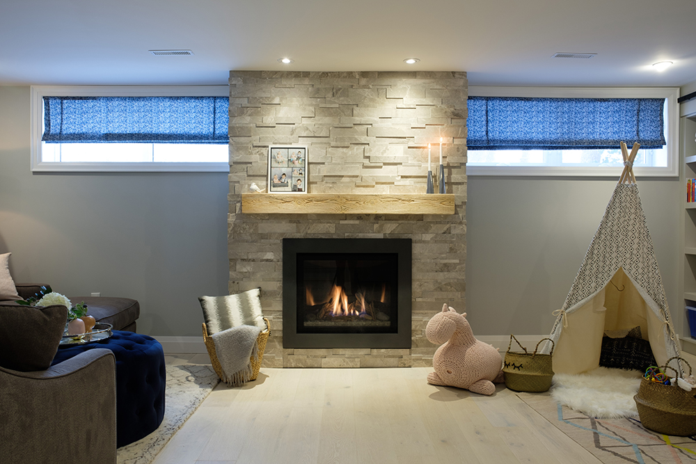 Stylish family room with gas fireplace with a wood mantle, a pink stuffed horse and a play teepee
