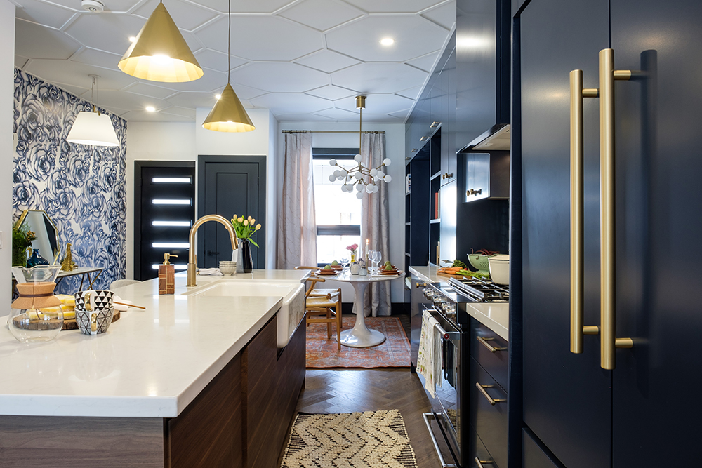 Blue cabinets, a large centre island and two gold pendant lamps feature in this modern kitchen