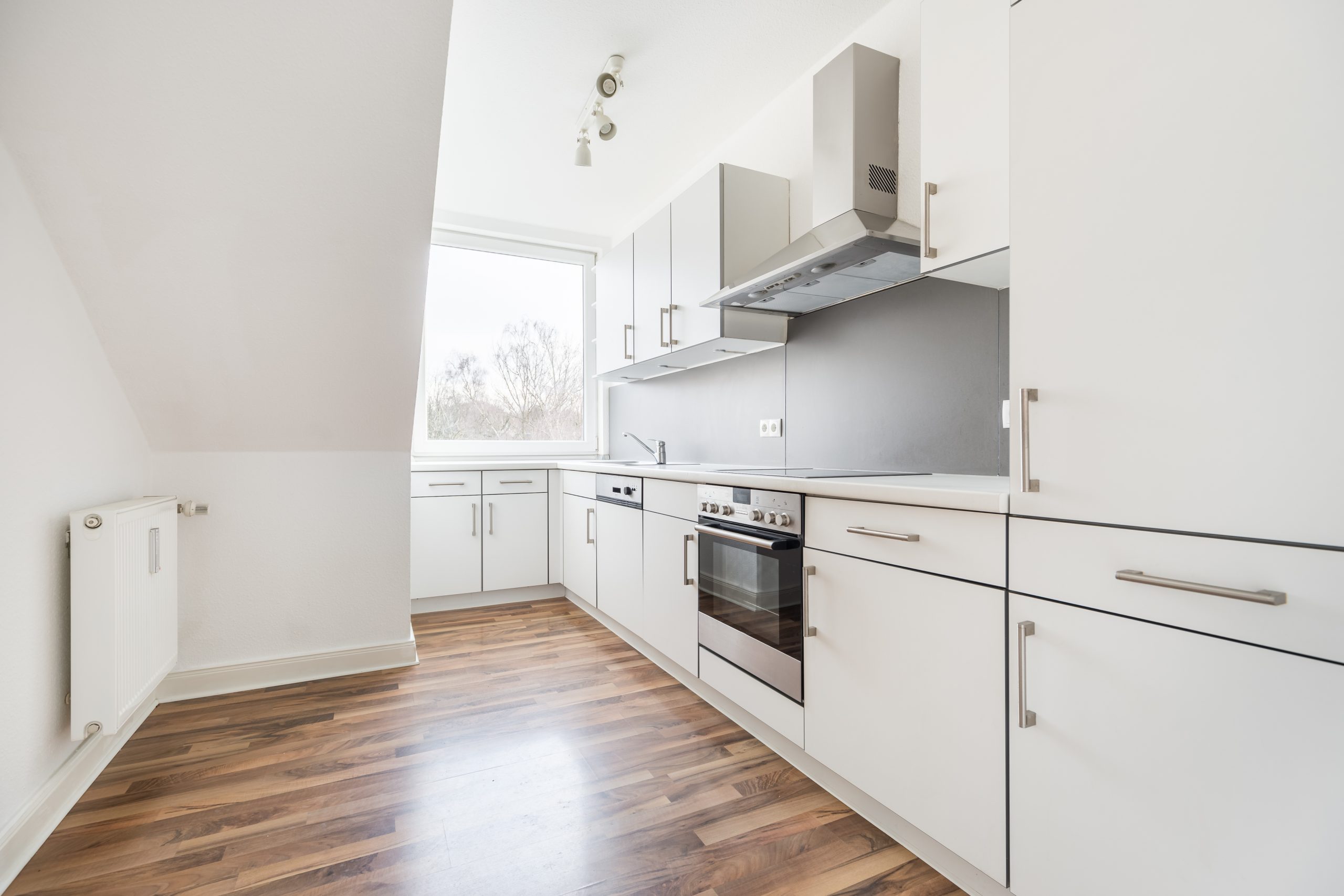 All-white kitchen with hardwood floors