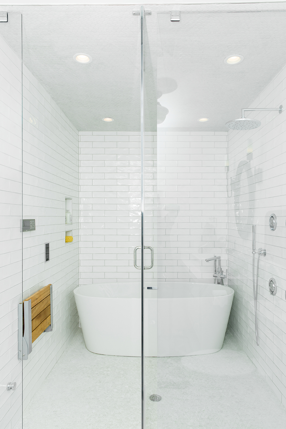 A glass-enclosed bathtub and shower.