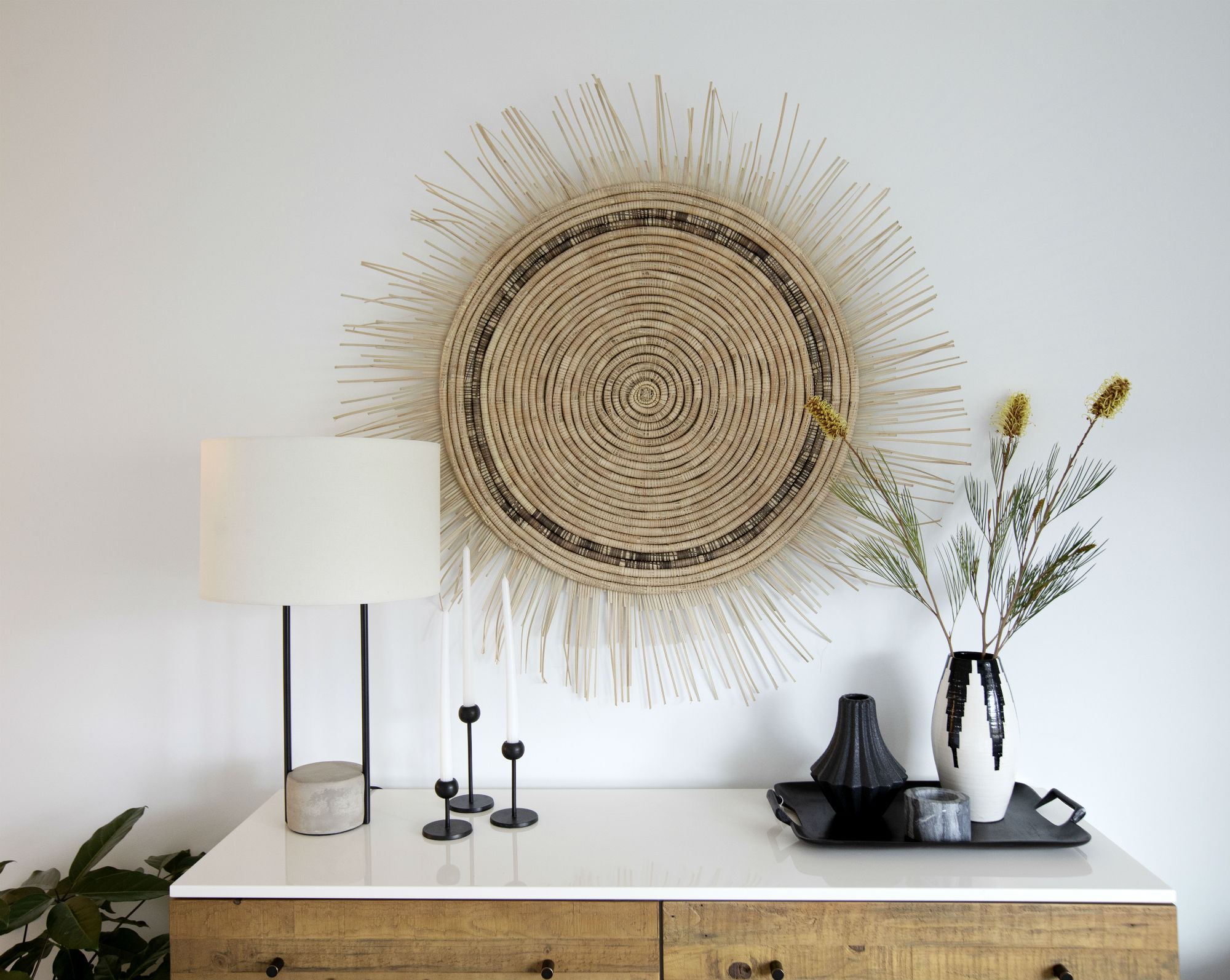 Round woven wall decor over console table