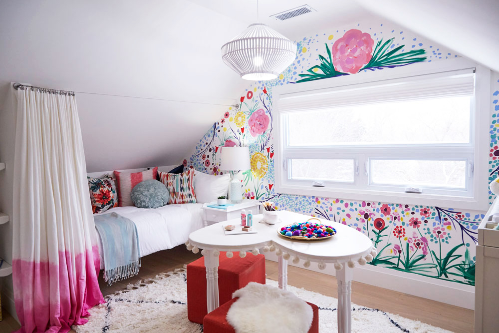 A whimsical kids' bedroom with a hand-painted floral wall mural