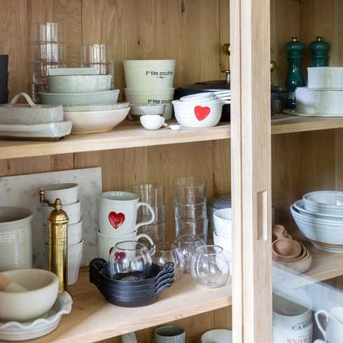 A cupboard with various thrifted kitchen items