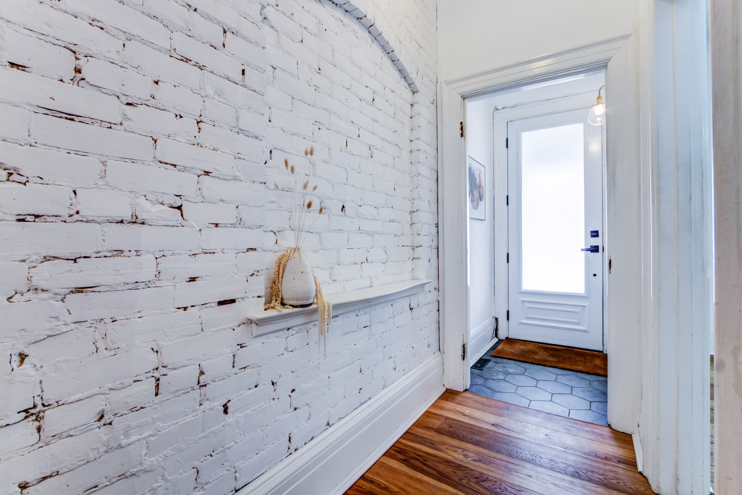 Exposed brick painted white in the front foyer