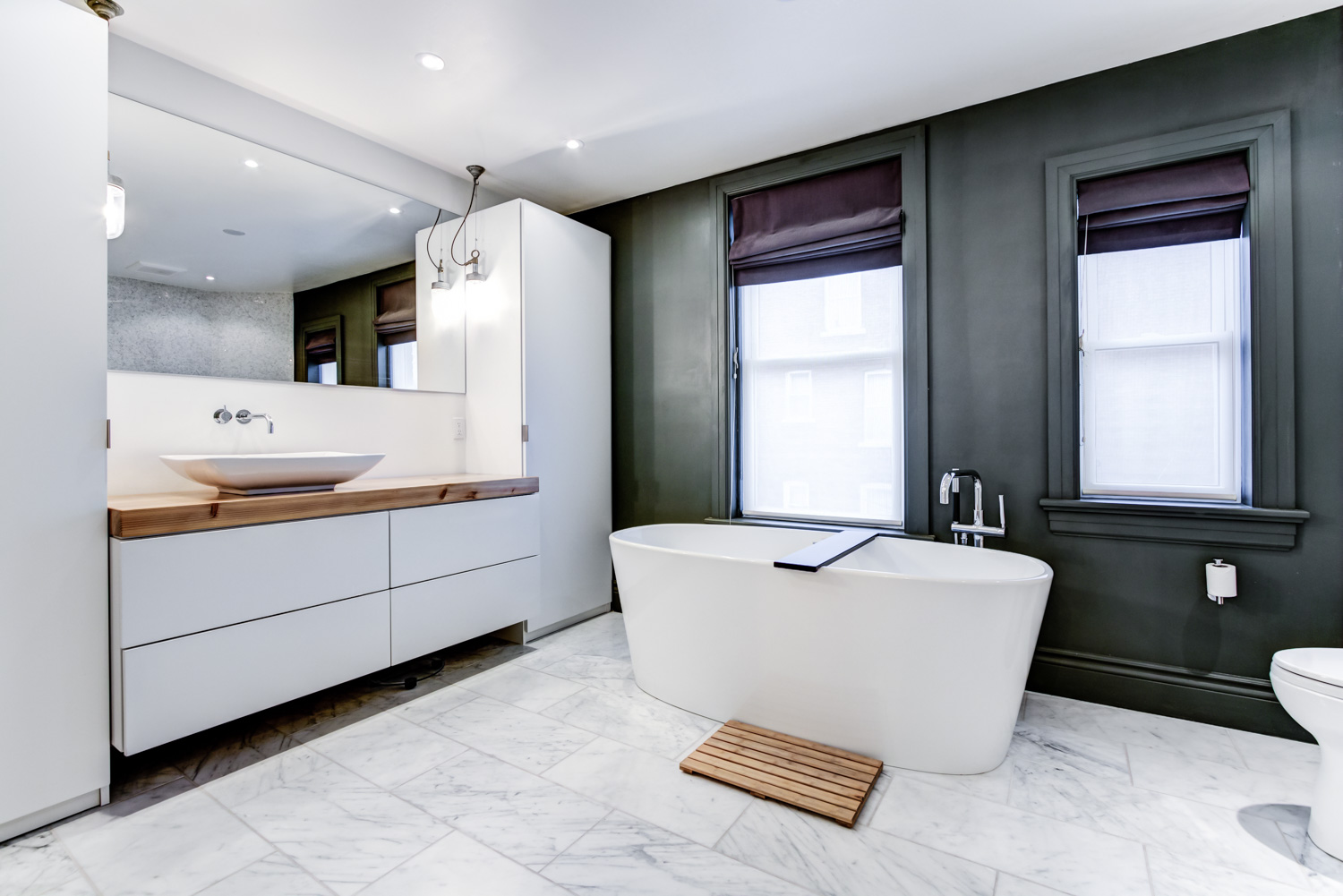 Master bathroom with white heated marble flooring and soaker tub