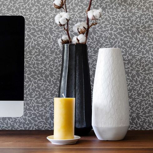 Close up of vases in front of grey patterned wallpaper