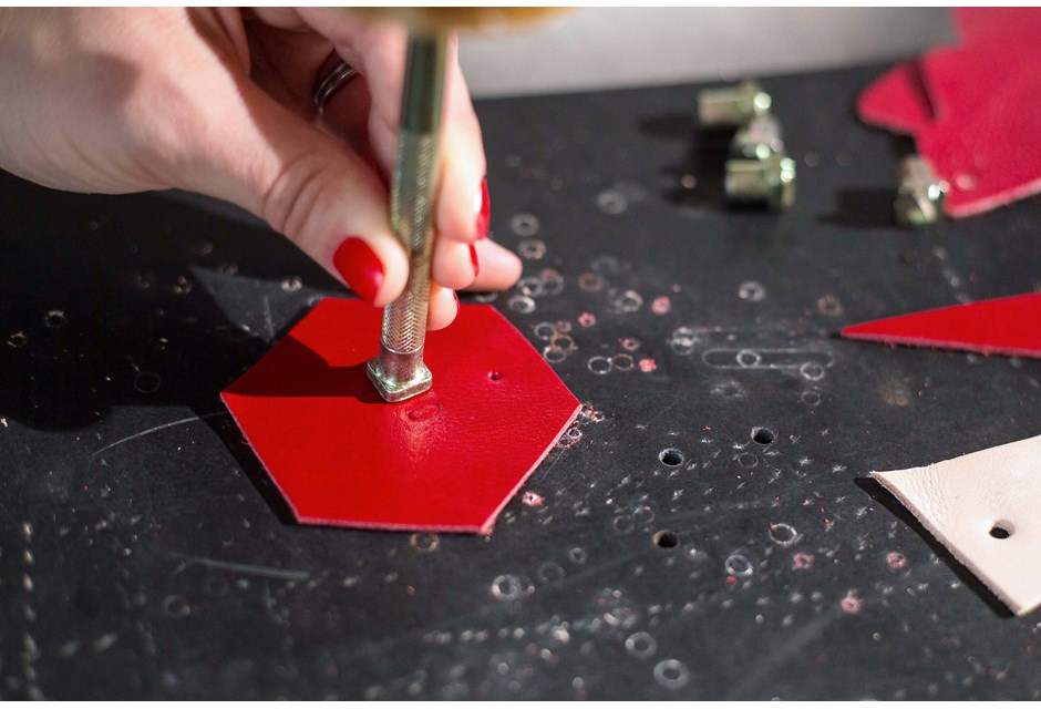 Stamping letters into red leather tag