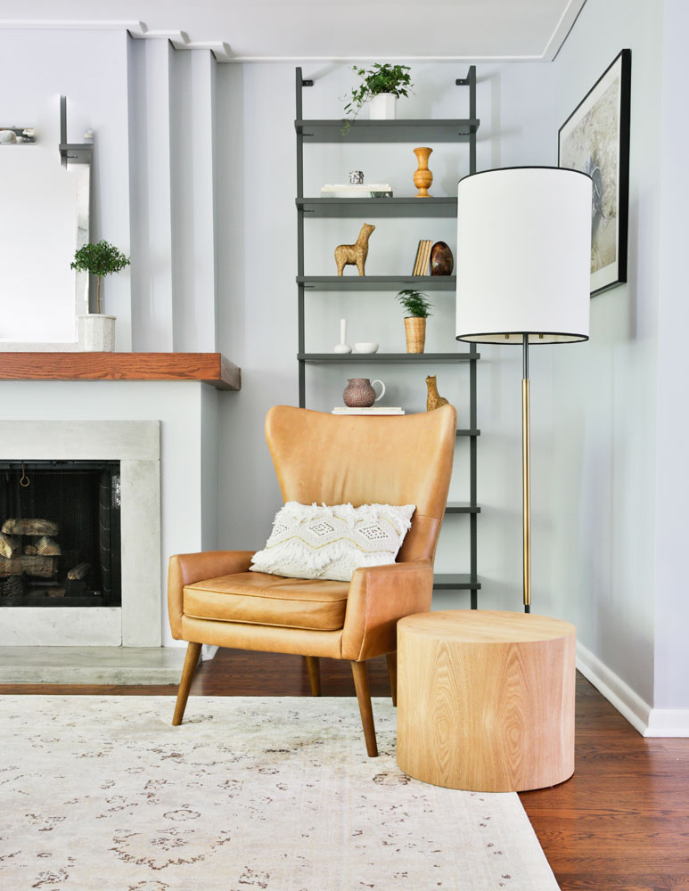 tan leather chair in corner by fireplace beside floor lamp