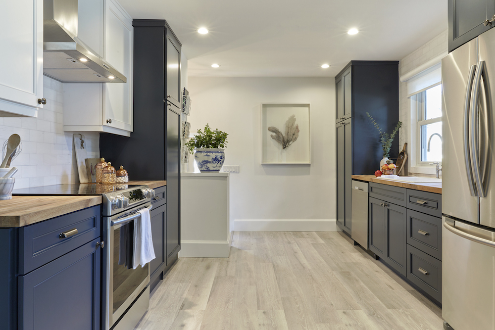 Buyers Bootcamp detached bungalow renovated kitchen with new grey-stained floors and navy-blue cabinets