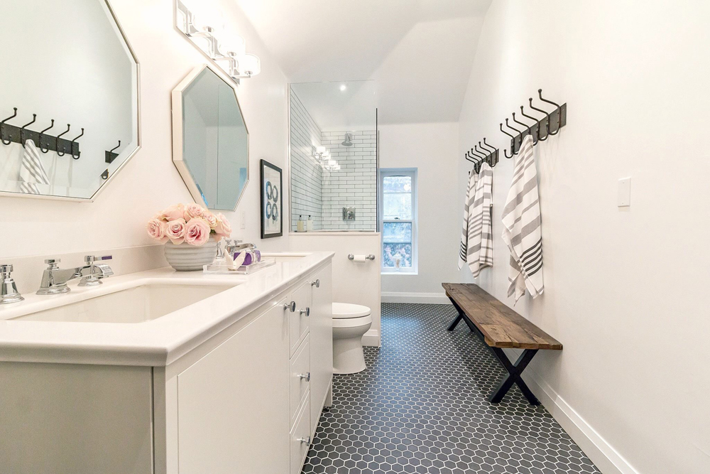 Spacious white bathroom with bold black hexagonal floor tiles.