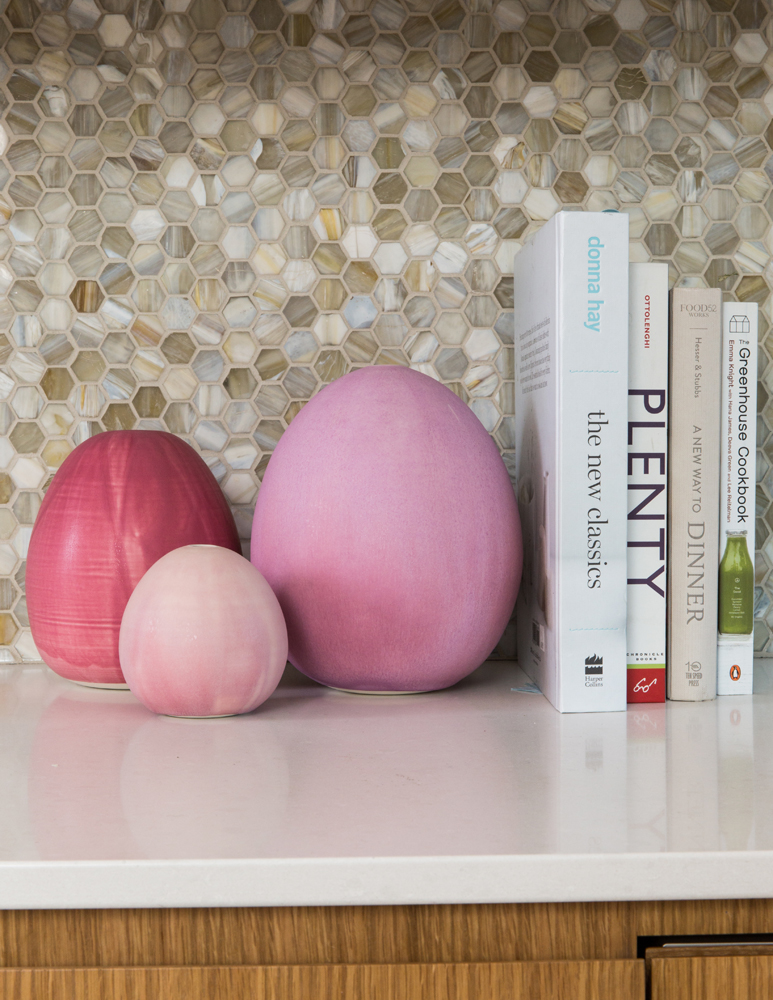 Three pink rounded sculptures beside cookbooks