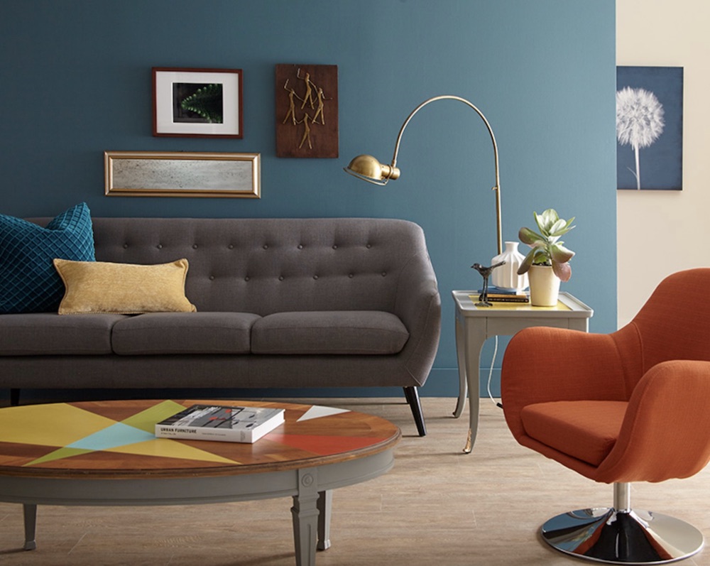 Colourful mid-century modern living room with a grey couch, orange egg chair, and a coffee table painted with BEHR Chalk Decorative Paint