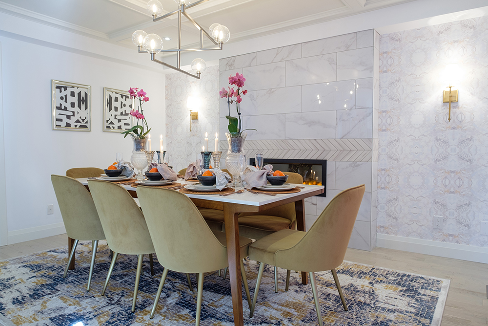 Chic dining room with yellow velvet chairs, a retro globe chandelier and marble tiled walls