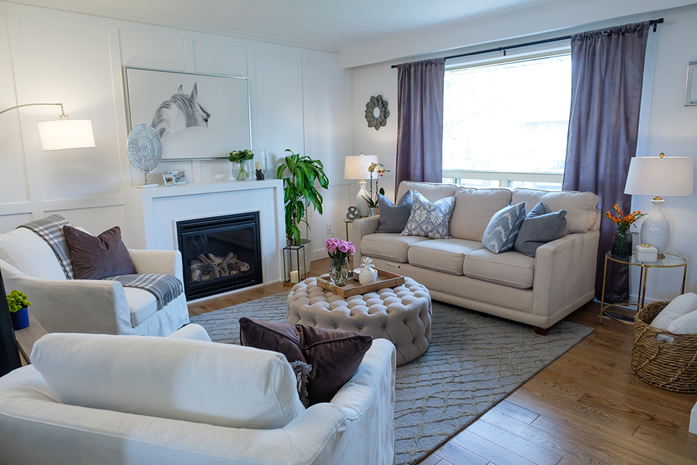 Modern living room with white tufted ottoman, white couch and horse portrait