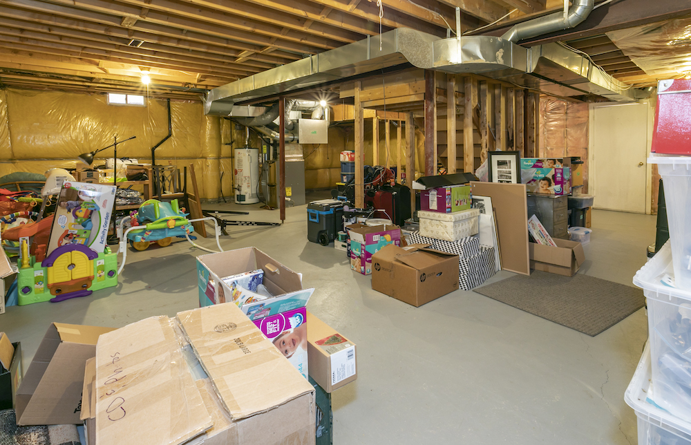 Unfinished basement stuffed with storage boxes and children's toys