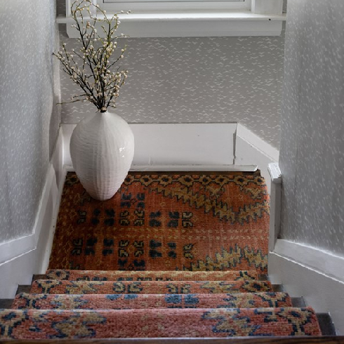 A staircase with patterned rug
