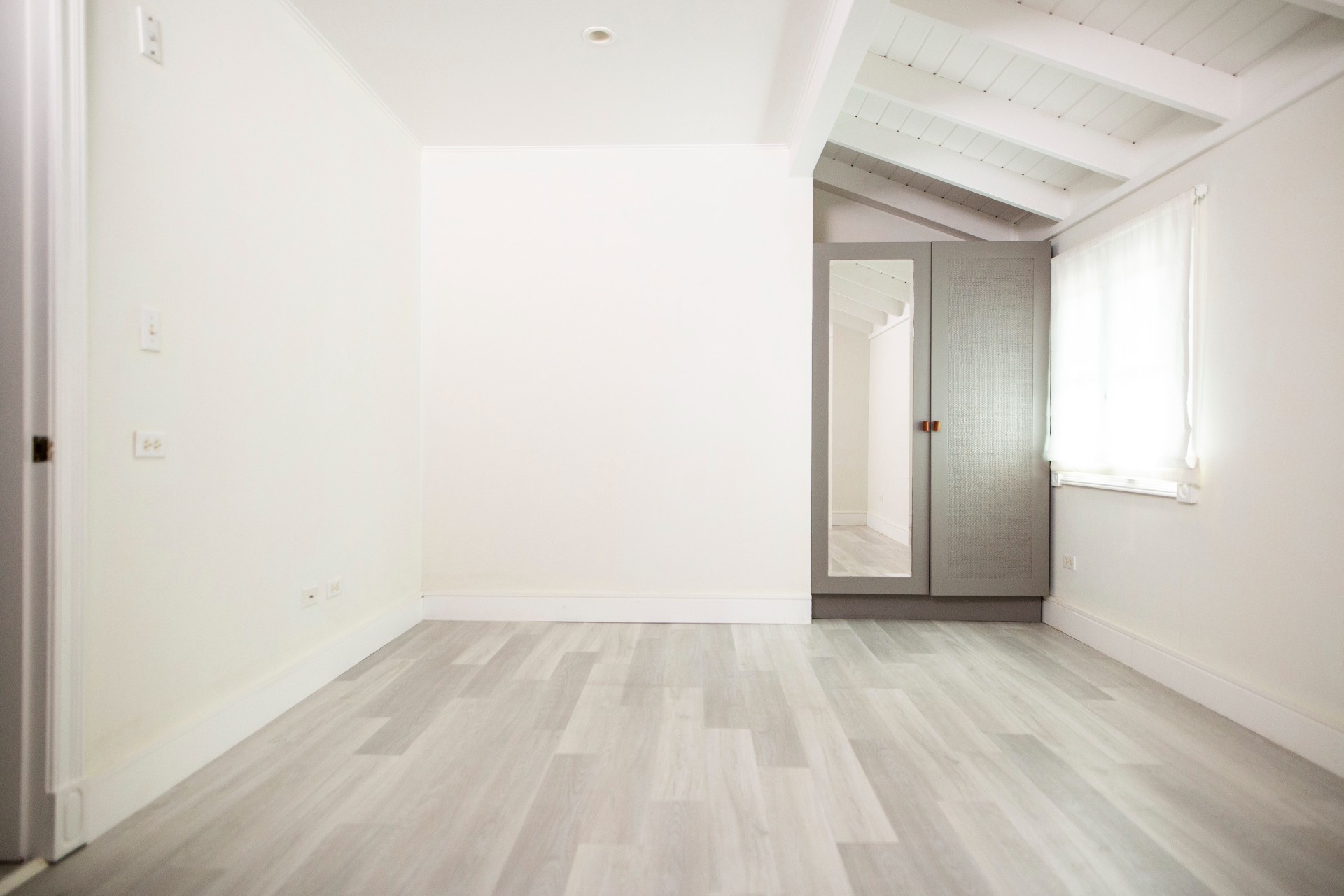 Empty bunk room with grey floor and white walls