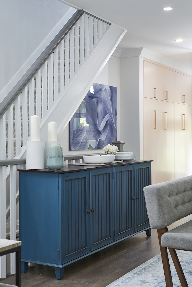 modern entryway with blue cabinet in front of staircase