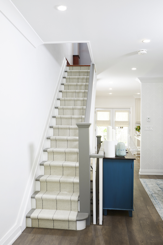 white open-concept living space with carpeted staircase